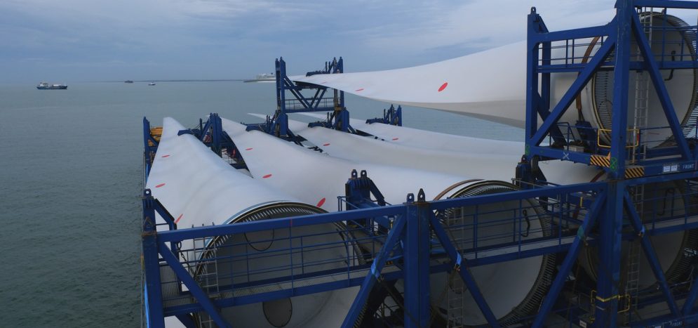 Blades with root ends of wind turbine loaded and lashed on the heavy load carrier vessel.